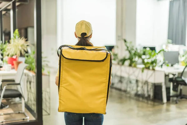 Back view of courier with thermo backpack standing in office — Stock Photo