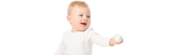 Lindo niño sosteniendo huevo de Pascua en la mano extendida con la boca abierta aislada en blanco, tiro panorámico - foto de stock