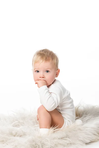 Cute boy putting hand in mouth, looking at camera isolated on white — Stock Photo
