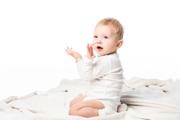 Vista lateral de un niño lindo arrodillado con las manos levantadas y la boca abierta aislada en blanco - foto de stock