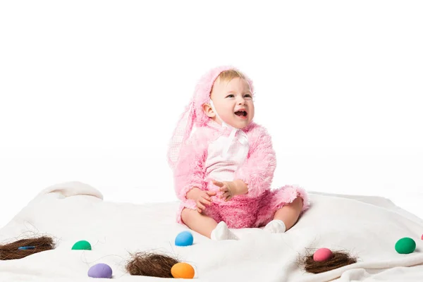 Kind im Hasenkostüm, schreit auf Decke mit farbenfroher Dekoration, isoliert auf weiß — Stockfoto