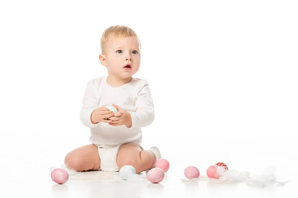 Criança com boca aberta, segurando o ovo de Páscoa no fundo branco — Fotografia de Stock