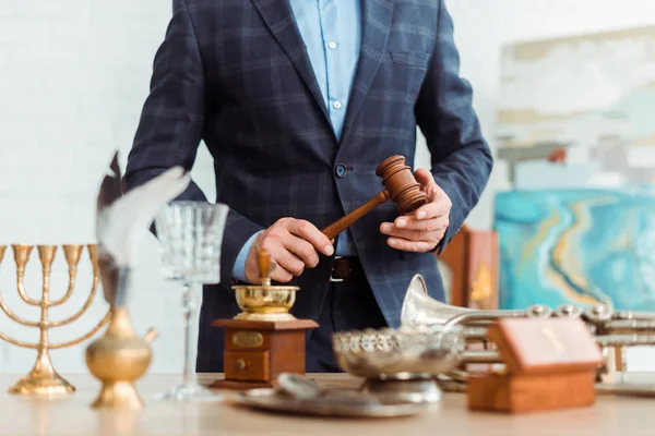 Cropped view of auctioneer in suit holding gavel during auction — Stock Photo