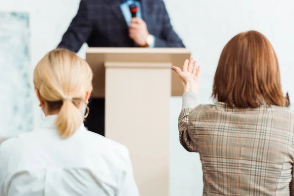 Rückansicht von Käufern, die den Auktionator anschauen und während der Auktion mit der Hand zeigen — Stockfoto