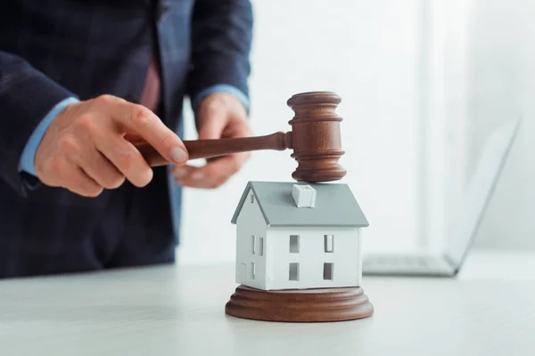 Cropped view of auctioneer hitting model of house with gavel — Stock Photo