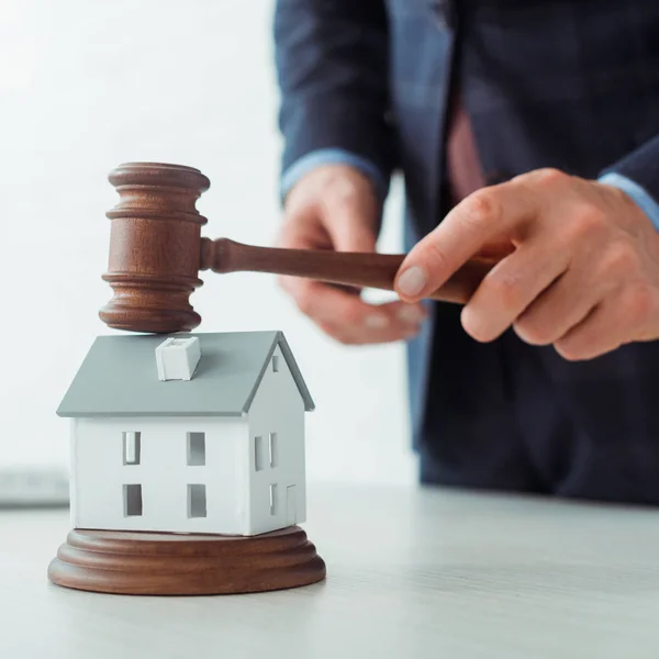 Cropped view of auctioneer hitting model of house with gavel — Stock Photo