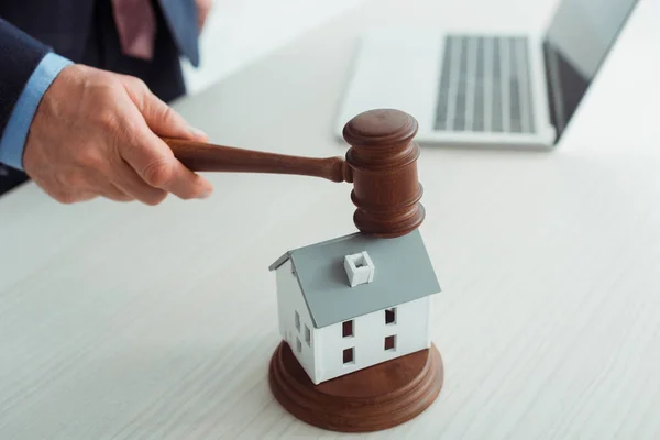 Cropped view of auctioneer hitting model of house with gavel — Stock Photo