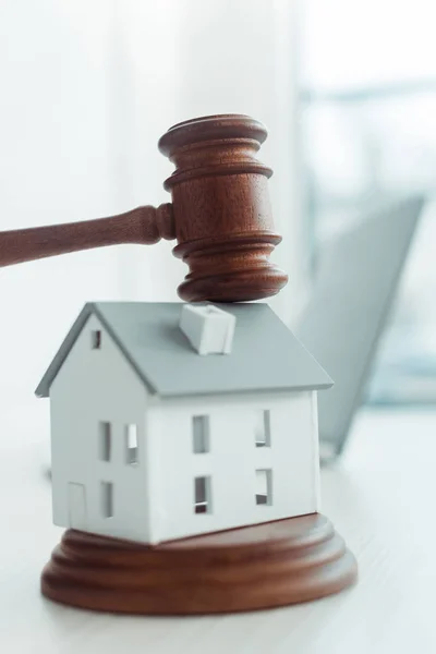 Wooden gavel and model of house on table — Stock Photo