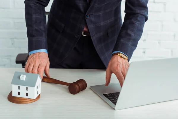 Cropped view of auctioneer holding gavel and using laptop — Stock Photo