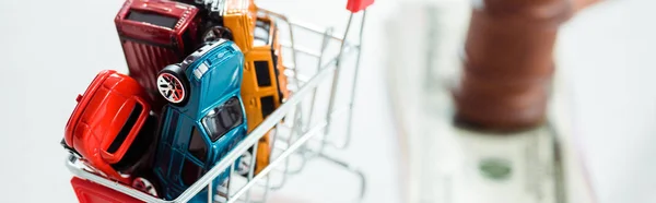 Panoramic shot of shopping trolley with models of cars — Stock Photo