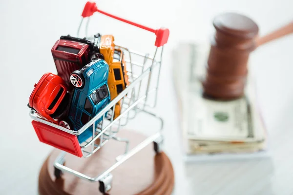 Selective focus of shopping trolley with models of cars — Stock Photo