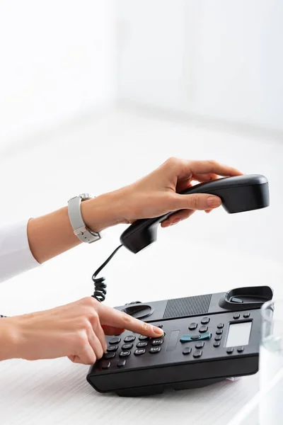 Обрізаний вид бізнес-леді, використовуючи телефон біля склянки води на столі — стокове фото