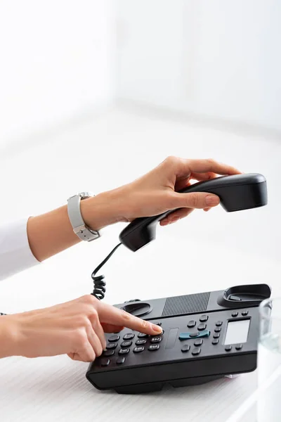 Vue recadrée de femme d'affaires en utilisant le téléphone près du verre d'eau sur la table — Photo de stock