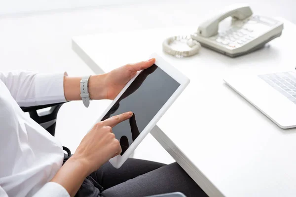 Vista recortada de la mujer de negocios utilizando tableta digital con pantalla en blanco en la mesa - foto de stock