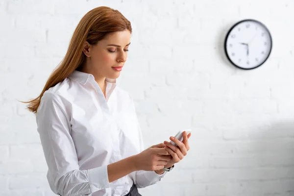 Belle femme d'affaires en utilisant smartphone dans le bureau — Photo de stock