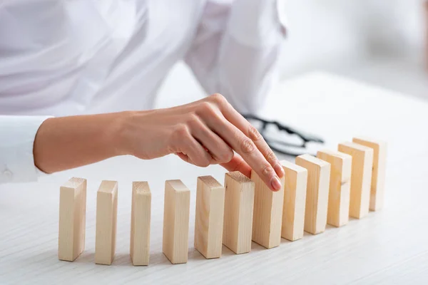 Vue recadrée de femme d'affaires jouant des blocs de construction en bois à table — Photo de stock