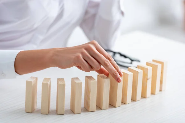 Vista ritagliata di donna d'affari che gioca mattoni di legno a tavola — Foto stock