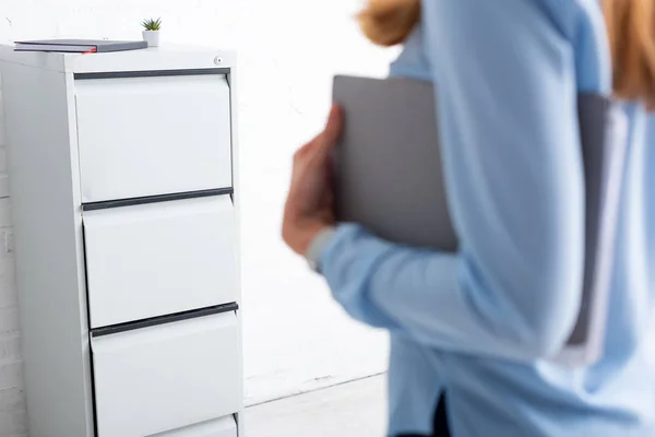 Selective focus of cabinet driver and businesswoman holding paper folder in office — Stock Photo