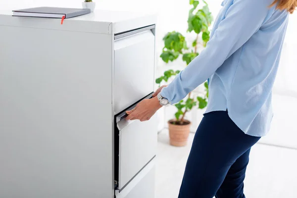 Vue recadrée du conducteur d'armoire d'ouverture de femme d'affaires au bureau — Photo de stock