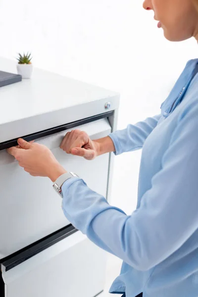 Cropped view of businesswoman opening cabinet driver isolated on white — Stock Photo