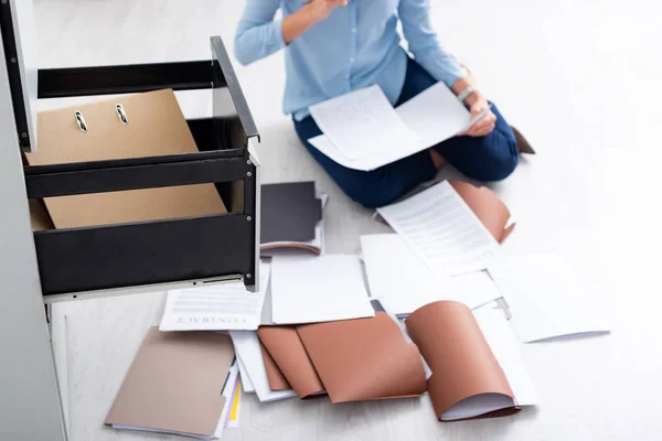 Cropped view of businesswoman with contract and documents near open cabinet driver on floor — Stock Photo