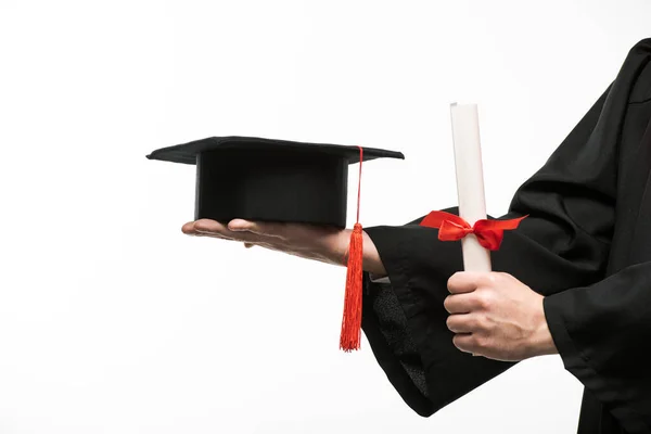 Vista ritagliata dello studente che tiene tappo laurea e diploma isolato su bianco — Foto stock