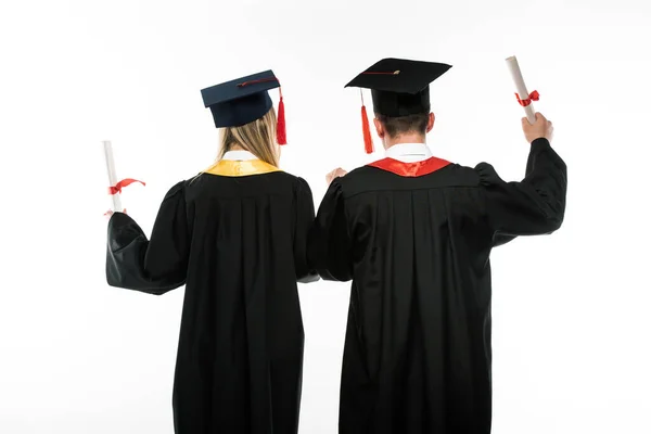 Vista posterior de los estudiantes con diplomas aislados en blanco - foto de stock