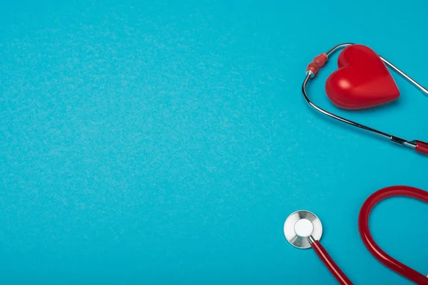 Corazón decorativo y estetoscopio sobre fondo azul, concepto del día mundial de la salud - foto de stock