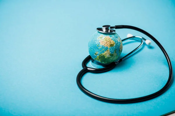 Estetoscópio com globo em fundo azul, conceito de dia de saúde mundial — Fotografia de Stock