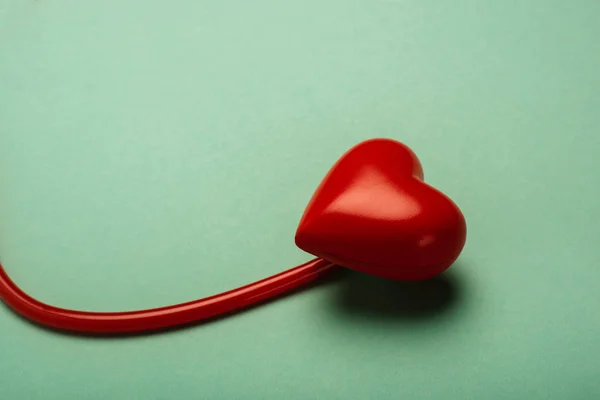 Coeur décoratif, stéthoscope rouge sur fond vert, concept de journée mondiale de la santé — Photo de stock