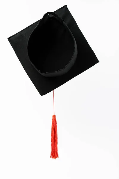 Vista superior de la gorra de graduación negra con borla roja aislada en blanco - foto de stock