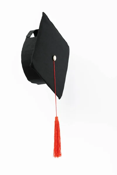 Graduation cap with red tassel isolated on white — Stock Photo