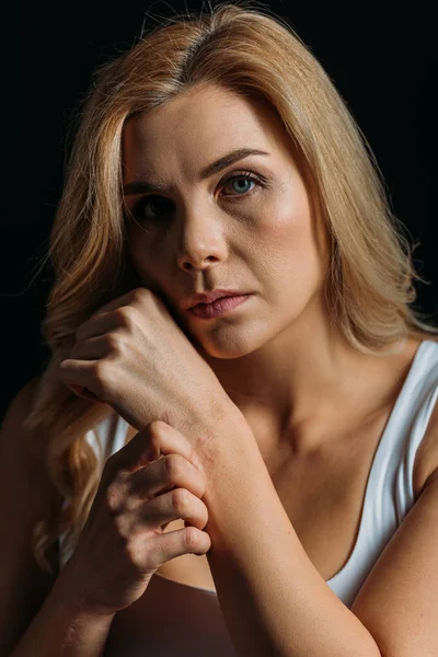 Frau berührt Hand und sieht Kamera isoliert auf schwarz — Stockfoto