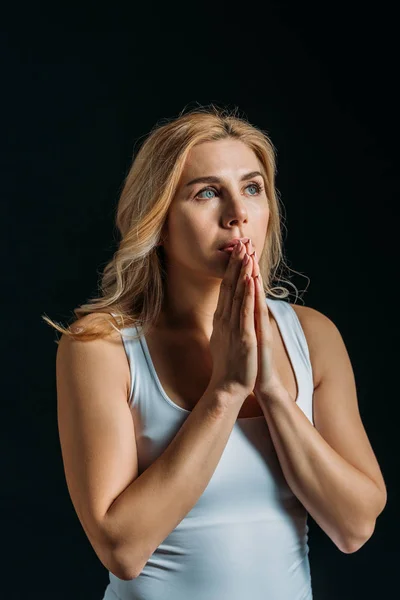 Schöne Frau betet isoliert auf schwarz — Stockfoto
