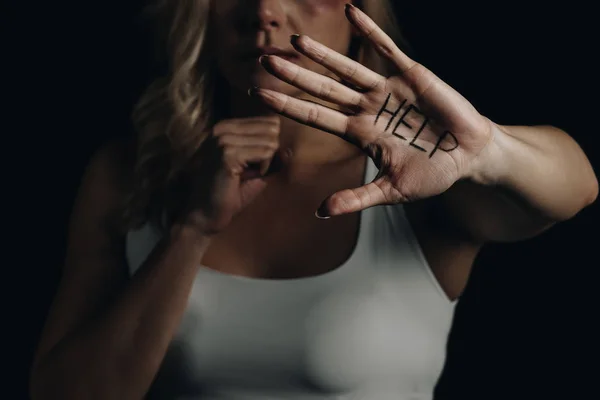 Обрезанный вид жертвы, показывающей руку с помощью надписей, изолированных на черном — стоковое фото