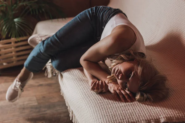 Selektiver Fokus der nachdenklichen Frau, die auf dem Sofa im Zimmer liegt — Stockfoto