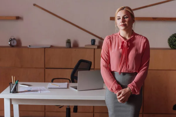 Front view of woman standing at table in office — Stock Photo