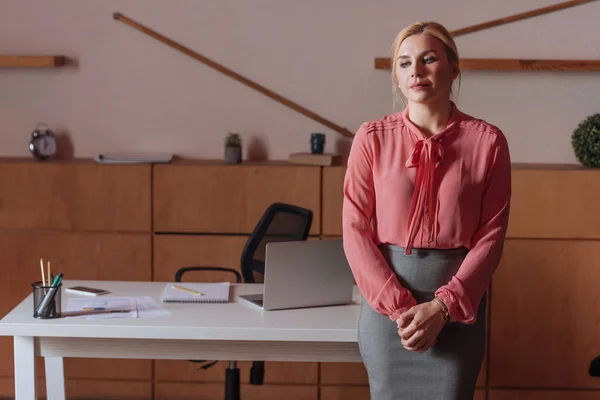 Вид женщины, стоящей за столом в офисе — стоковое фото