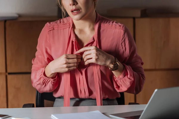 Cropped view of of woman buttoning pink blouse in office, sexual harassment concept — Stock Photo