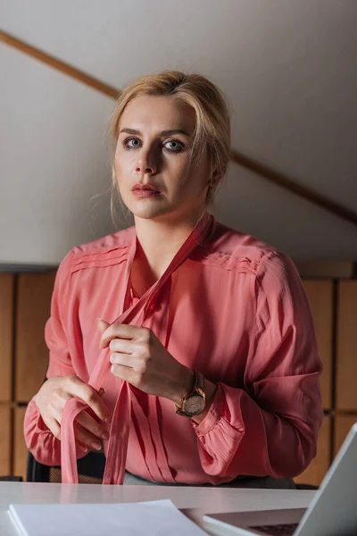 Selective focus of Victim holding ribbons on blouse in office, sexual harassment concept — Stock Photo