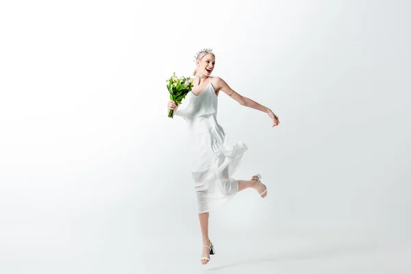 Happy beautiful tattooed bride jumping with bouquet isolated on white — Stock Photo