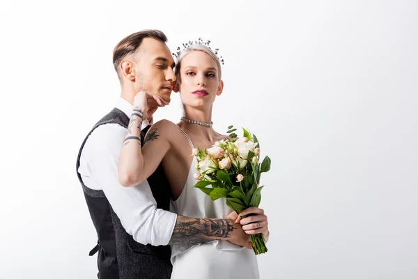 Beautiful tattooed bride and handsome bridegroom hugging isolated on white — Stock Photo