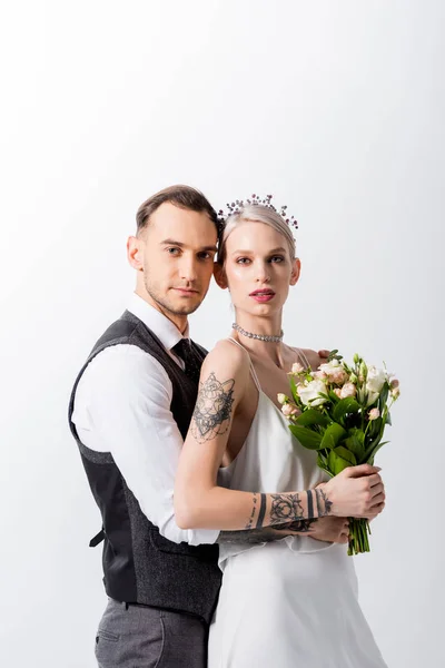 Bella sposa tatuata e bello sposo abbracciando isolato su bianco — Foto stock