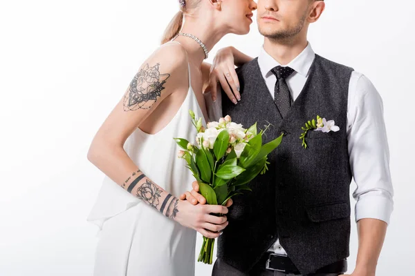 Обрізаний вид красивої татуйованої нареченої цілує красивого нареченого ізольовано на білому — стокове фото