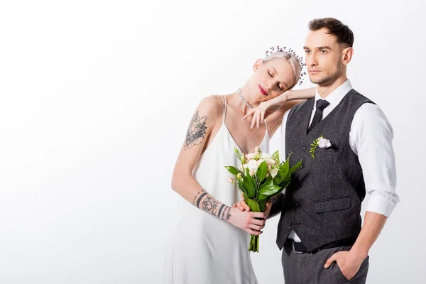 Schöne tätowierte Braut lehnt sich an schönen Bräutigam isoliert auf weiß — Stockfoto