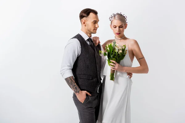 Schöne tätowierte Braut mit Strauß und hübschem Bräutigam isoliert auf weiß — Stockfoto