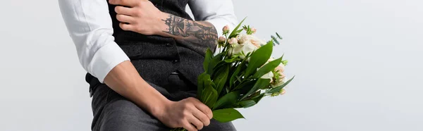 Cropped view of tattooed elegant bridegroom with bouquet isolated on grey, panoramic shot — Stock Photo