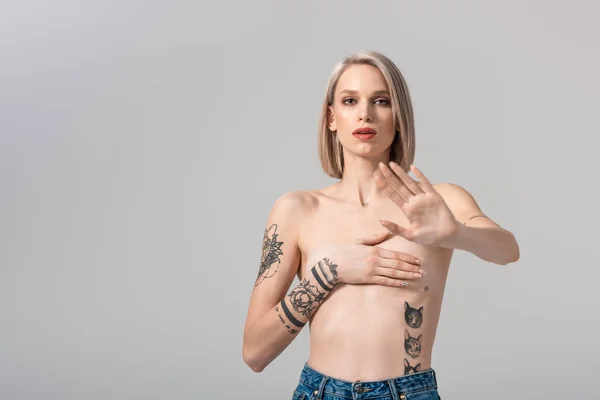 Sexy young topless tattooed woman showing no gesture isolated on grey — Stock Photo