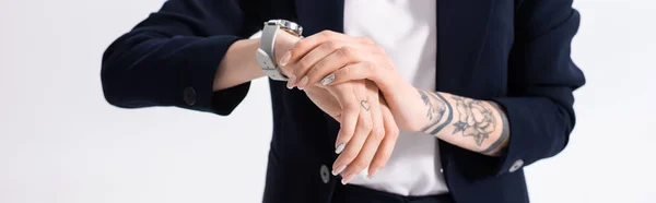 Vista ritagliata di successo giovane donna d'affari tatuata con orologio da polso a portata di mano isolato su bianco, colpo panoramico — Foto stock