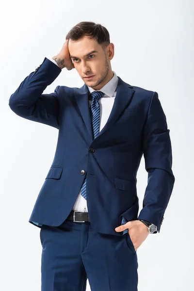 Exitoso hombre de negocios joven tatuado en traje azul posando aislado en blanco - foto de stock